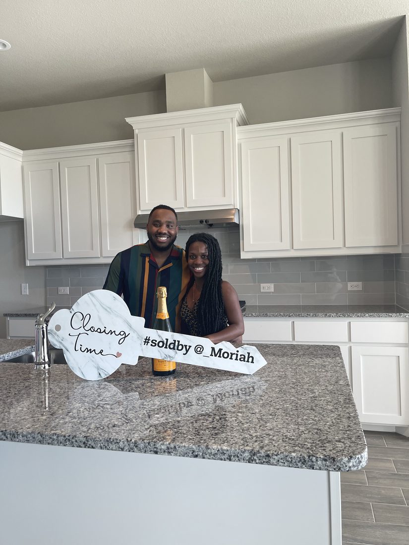 Couple celebrating their home closing with champagne in their new kitchen